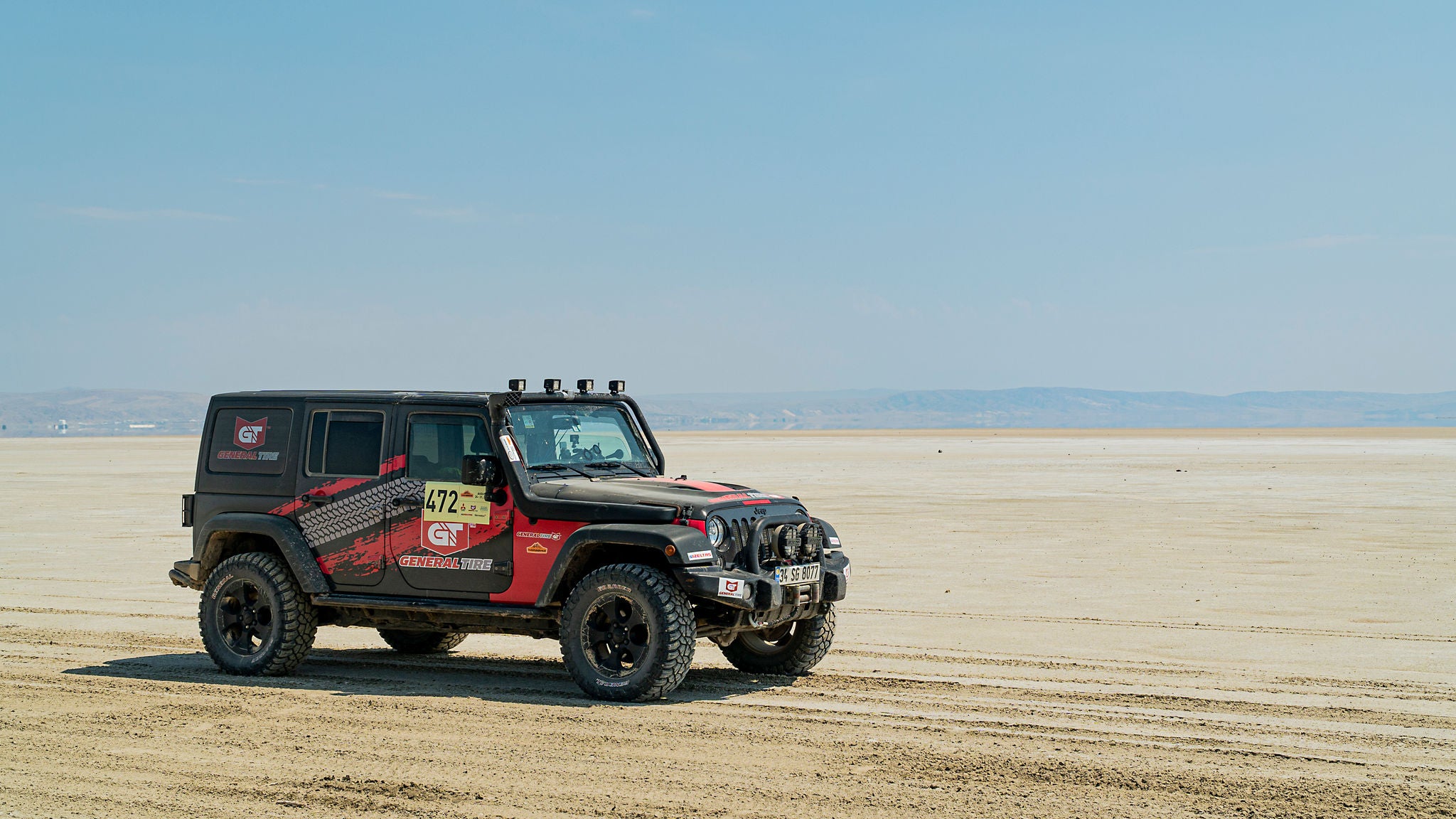 Car driving through flat desert